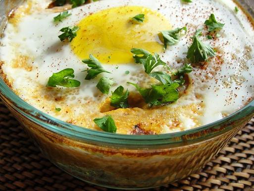 Baked eggs over roasted tomatoes and citrus herb couscous